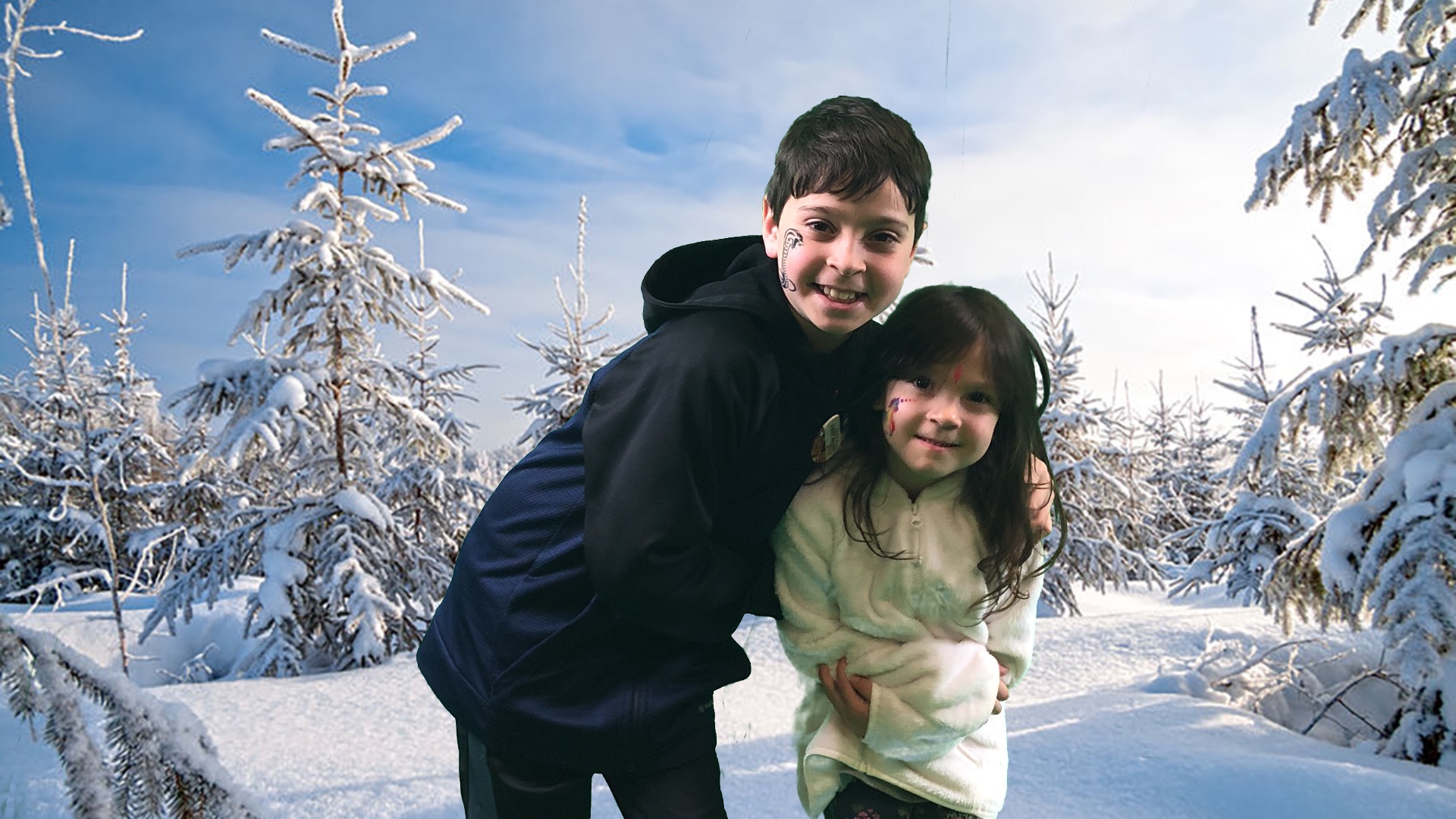boy and girl standing in snow with snow covered trees in the background