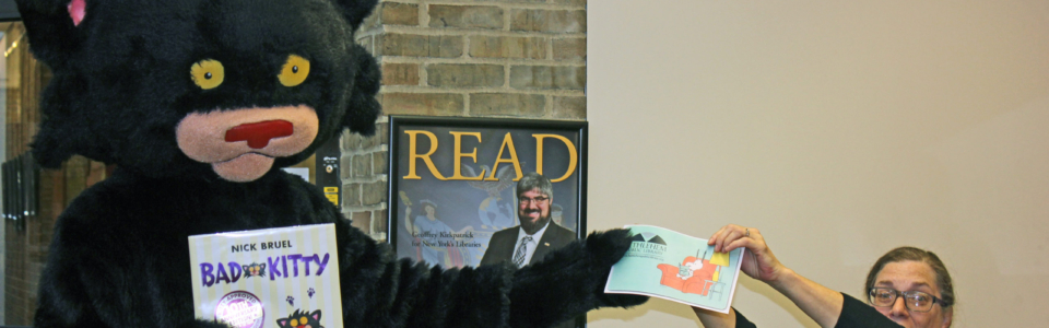 Costumed bad kitty being handed a library card